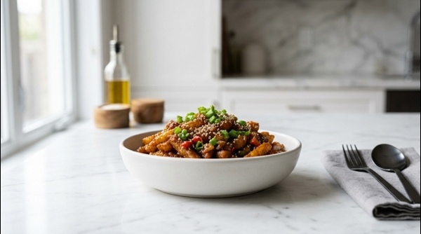 A plate of crispy Chilli Potato garnished with sesame seeds and spring onions
