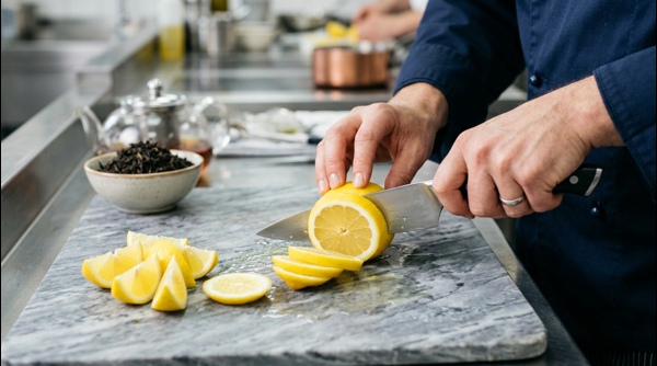 Fresh ginger simmering in a pot of water on a modern induction stove