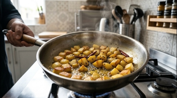 Finished Aloo Posto in a modern ceramic bowl garnished with fresh green chillies