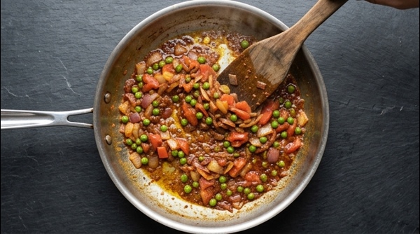 A finished plate of smoky Baingan Bharta garnished with coriander and green peas
