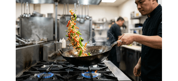 The finished veg fried rice being tossed in a modern kitchen wok