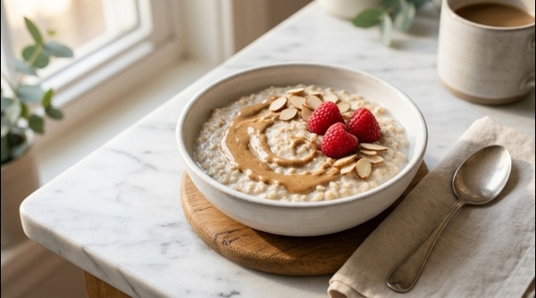 A beautiful bowl of creamy oatmeal topped with fresh blueberries and sliced almonds on a marble countertop