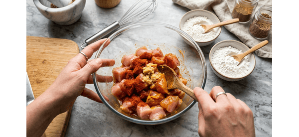 Chicken pieces being marinated with ginger garlic paste and spices in a glass bowl Chicken pieces being marinated with ginger garlic paste and spices in a glass bowl