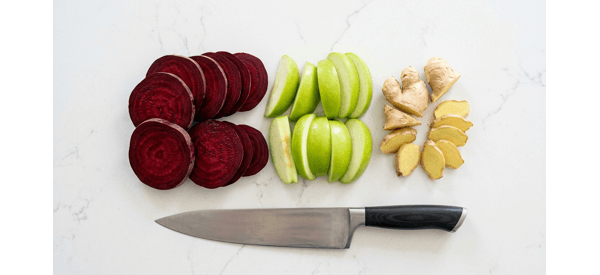 Chopped raw beetroots, apples, and ginger on a clean white surface Chopped raw beetroots, apples, and ginger on a clean white surface