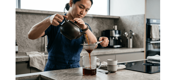 Pouring the clear amber iced tea over a glass filled with ice cubes and lemon Pouring the clear amber iced tea over a glass filled with ice cubes and lemon