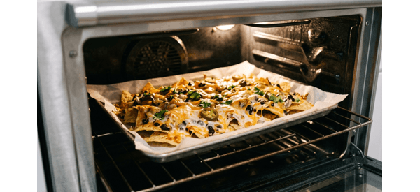Finished cheesy vegetable nachos served on a modern platter Finished cheesy vegetable nachos served on a modern platter