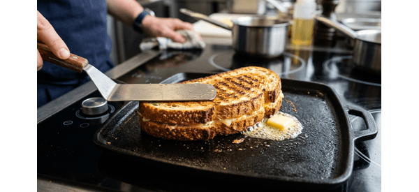 Final grilled paneer sandwich cut diagonally on a clean plate